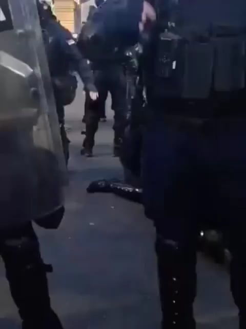 The cop is wearing a nano leg (you can see it light up at 0:28)