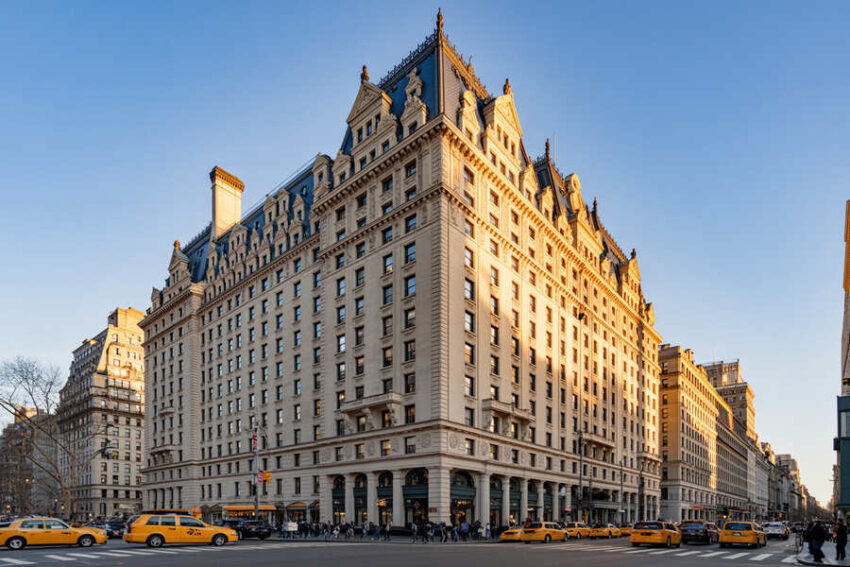 Luxury hotel in nyc with taxis, showcasing vibrant urban tourism.