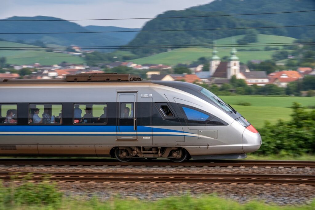 High-speed train traveling through scenic european landscape.