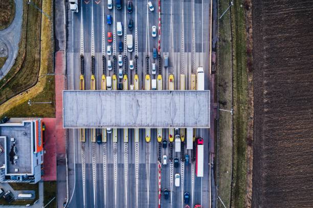 Aerial view of a highway toll plaza with multiple lanes of cars passing through booths