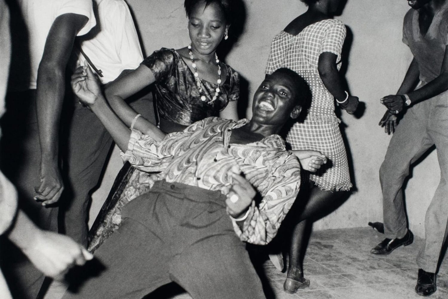 A person is shown dancing in a crowd, leaning back.