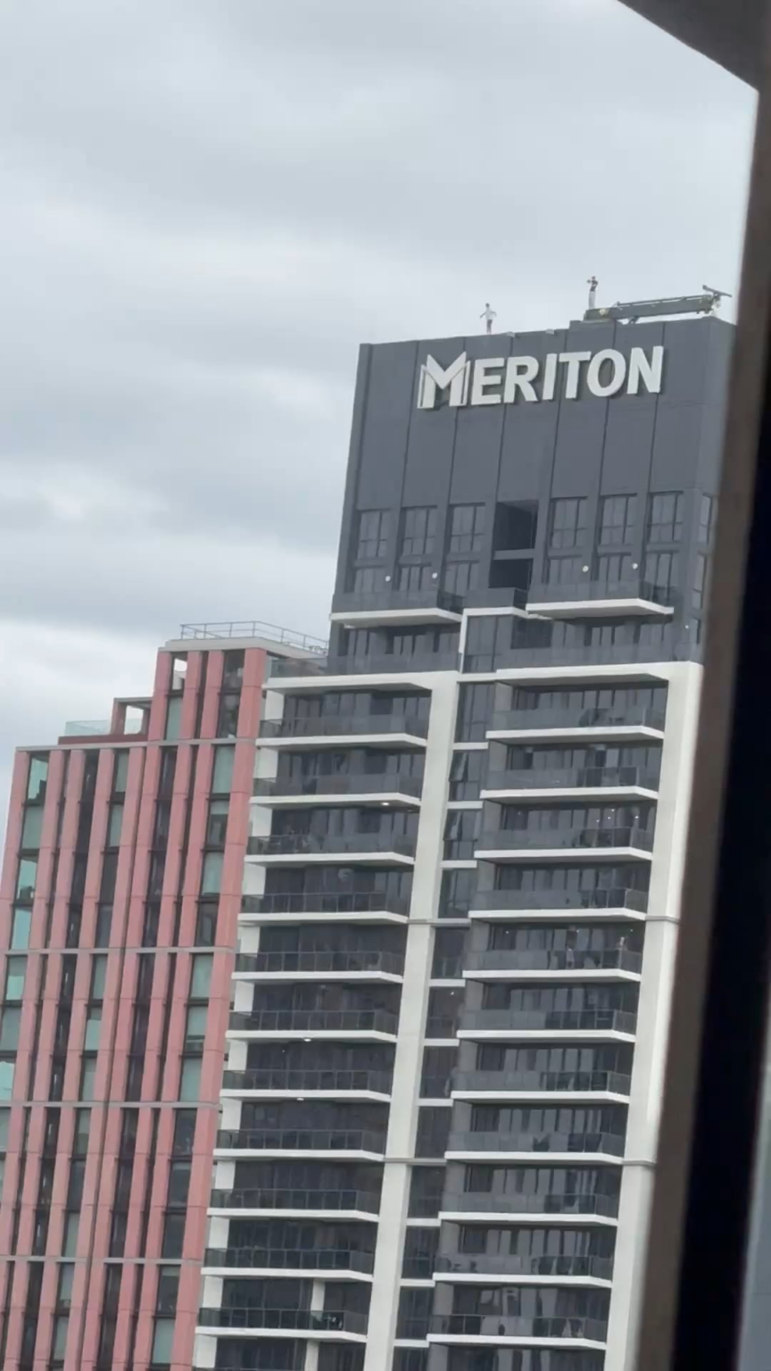 2 guys taking selfies on top of the Meriton in Sydney CBD