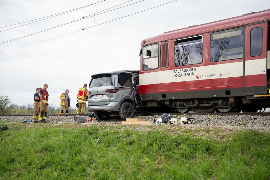 Car and train crash. Train into side of car, resting on railway