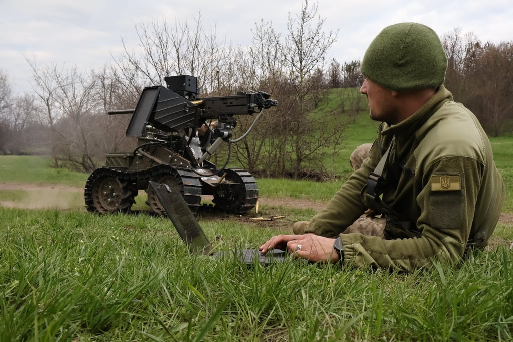 A Ukrainian serviceman prepares a machine gun on a combat ground drone in the Zaporizhzhia region. Photo: Ukraine’s 65th Mechanised Brigade via AP