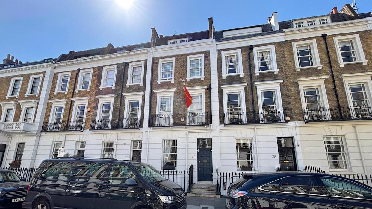 A row of residential two-story town houses on a London street can be seen, with the  embassy at door number "40", along with the red flag of Montenegro