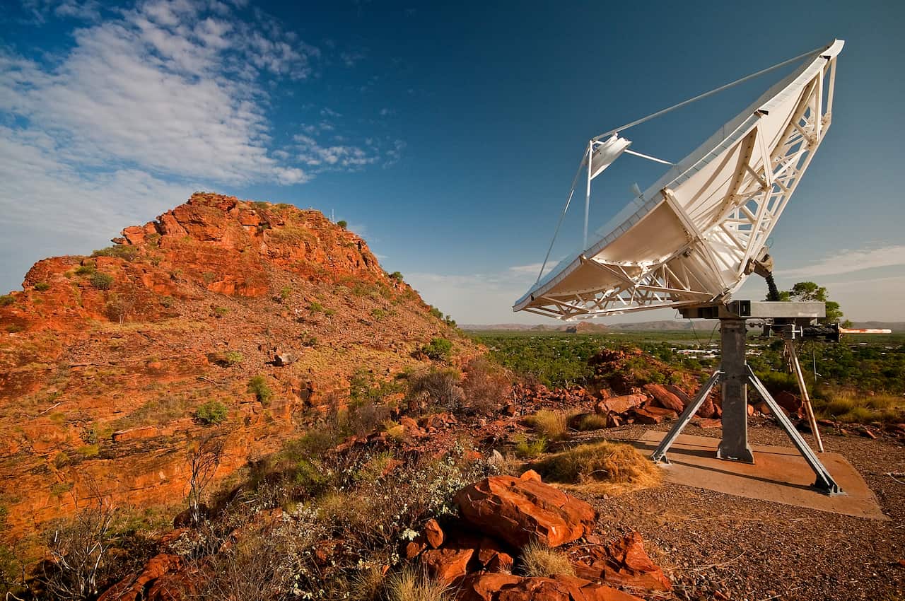 Satellite Dish in the outback in Western Australia facing a hill formation