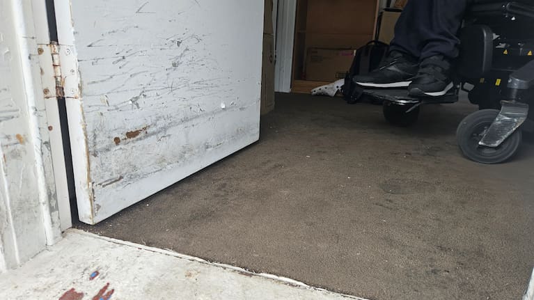 The front door to Neki's temporary unit has been consistently hit and scraped as he struggles to fit his wheelchair through it.