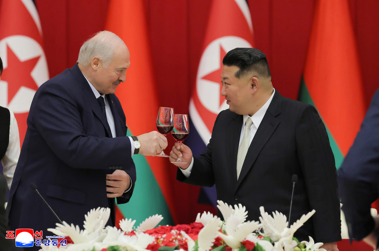 North Korean leader Kim Jong-un (R) and Belarusian President Alexander Lukashenko make a toast during a banquet hosted by Kim for the Belarusian leader in Pyongyang on March 26, following their summit talks. (Yonhap)