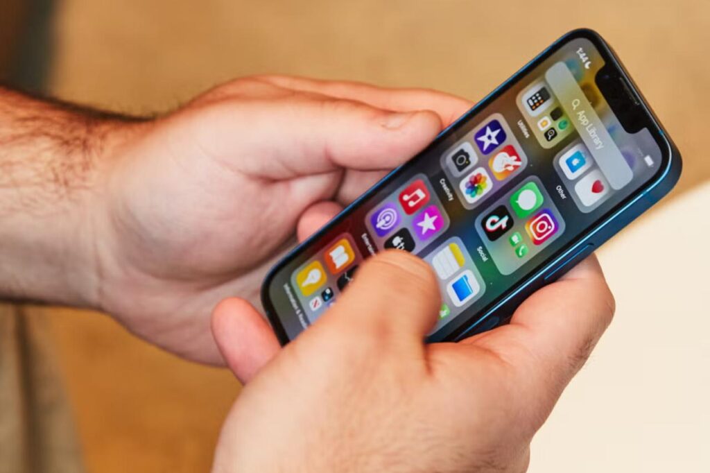 A person scrolling through social media on a smartphone, reflecting rising screen time and growing concerns over digital overuse. (Adobe Stock Photo)