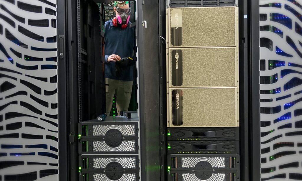 Prediction: The Nasdaq Could Soar to 30,000 by 2027. These Are the Best Artificial Intelligence (AI) Growth Stocks to Own Until Then. Person standing inside a data center with Nvidia chips.