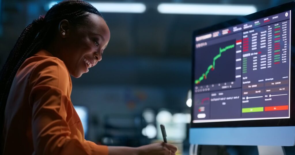 A person smiling while watching a stock chart rise.