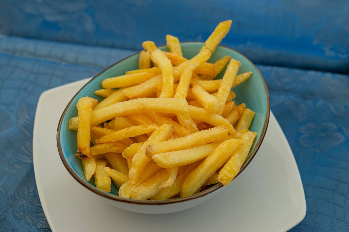Bowl of fresh french fries on a restaurant table