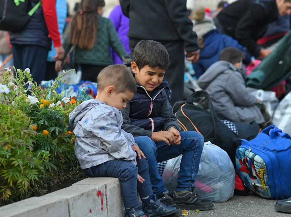 Children sit on a curb as residents gather in central Stepanakert to leave Nagorno-Karabakh, a region once inhabited by ethnic Armenians, September 25, 2023. REUTERS/David Ghahramanyan