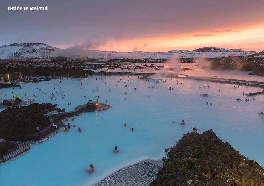 People relaxing in the Blue Lagoon’s geothermal waters at sunset, surrounded by lava fields and steamy mist. People relaxing in the Blue Lagoon’s geothermal waters at sunset, surrounded by lava fields and steamy mist.