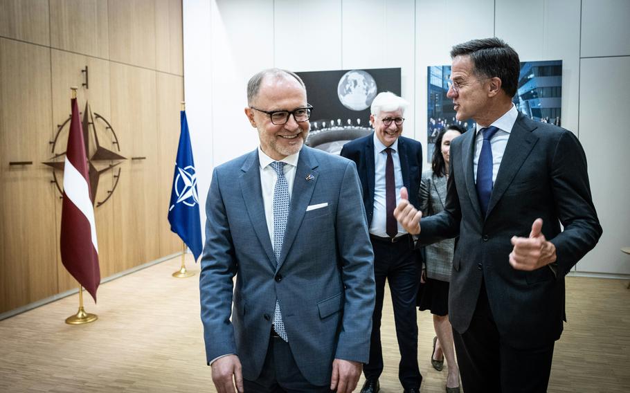 European officials walk through the halls of NATO headquarters.