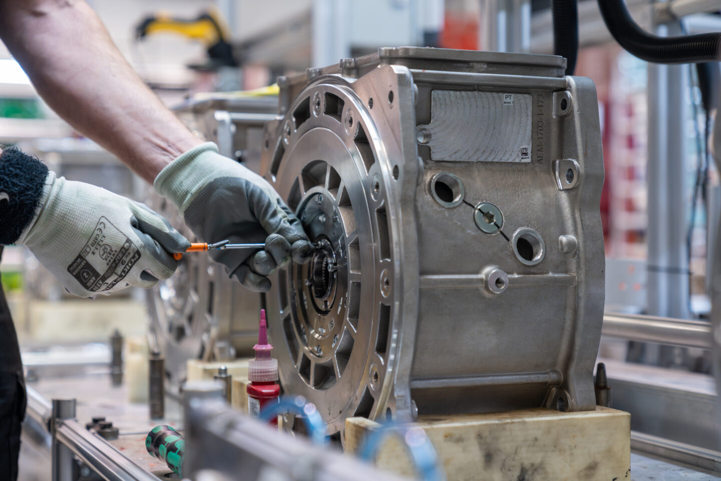 Hands at a workman assembling an AEM rare earth-free motor in a factory