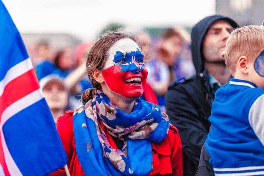 Icelander woman with Iceland flag face paint smiling in Reykjavik during national celebration. Icelander woman with Iceland flag face paint smiling in Reykjavik during national celebration.