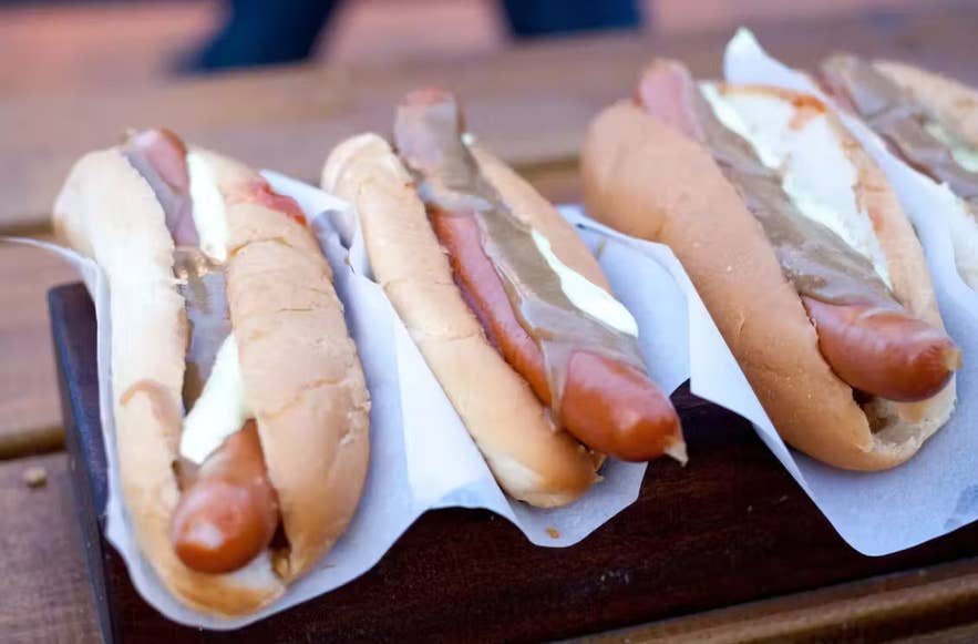 Icelanders eat traditional hot dogs with crispy onions and sauces at a Reykjavik Street Food Stall. Icelanders eat traditional hot dogs with crispy onions and sauces at a Reykjavik Street Food Stall.