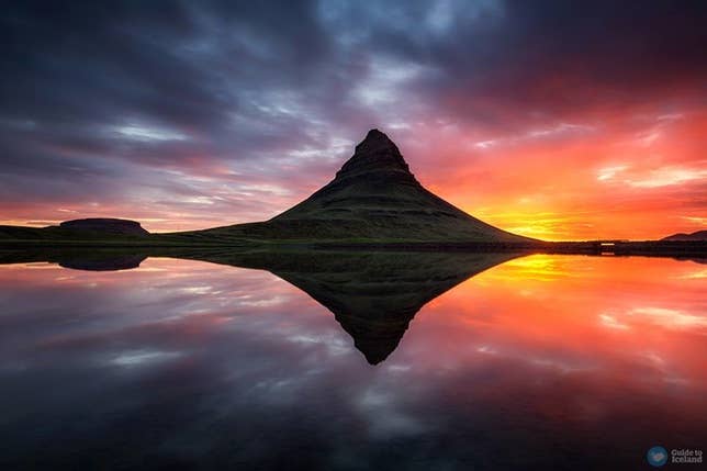 Kirkjufell Mountain in Iceland reflected in still water at sunset, with vibrant orange, red, and purple colors in the sky. Kirkjufell Mountain in Iceland reflected in still water at sunset, with vibrant orange, red, and purple colors in the sky.
