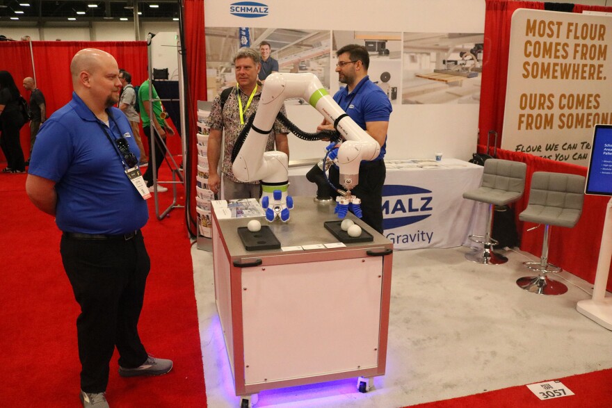 A robotic appendage seems to be picking up or setting down an egg. 