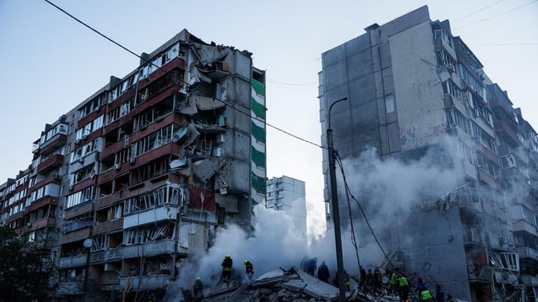 Rescue workers clear the rubble of a house heavily damaged...