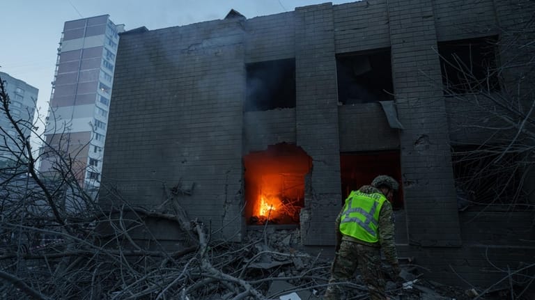 A policeman look at a building damaged after a Russian...