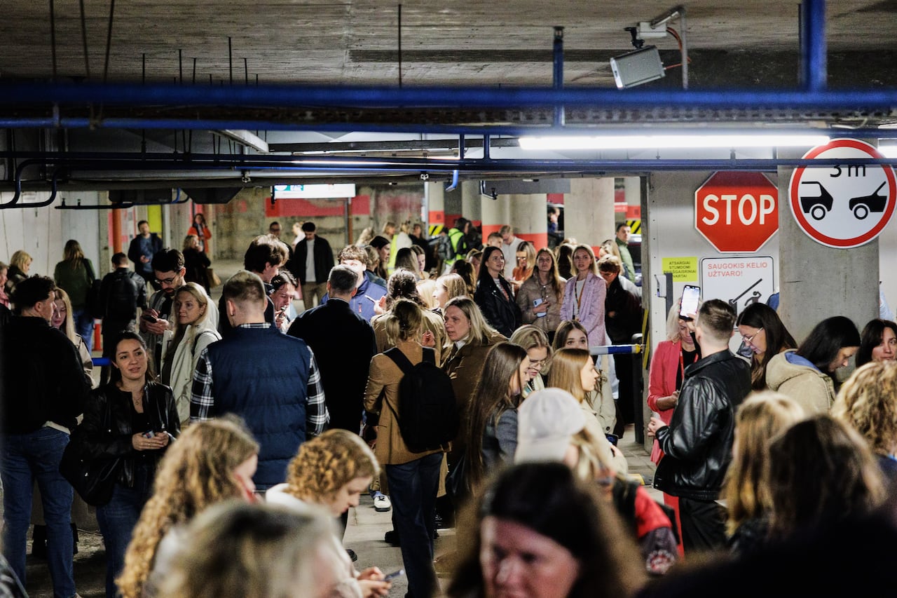 Dozens of people are shown in an underground transit platform