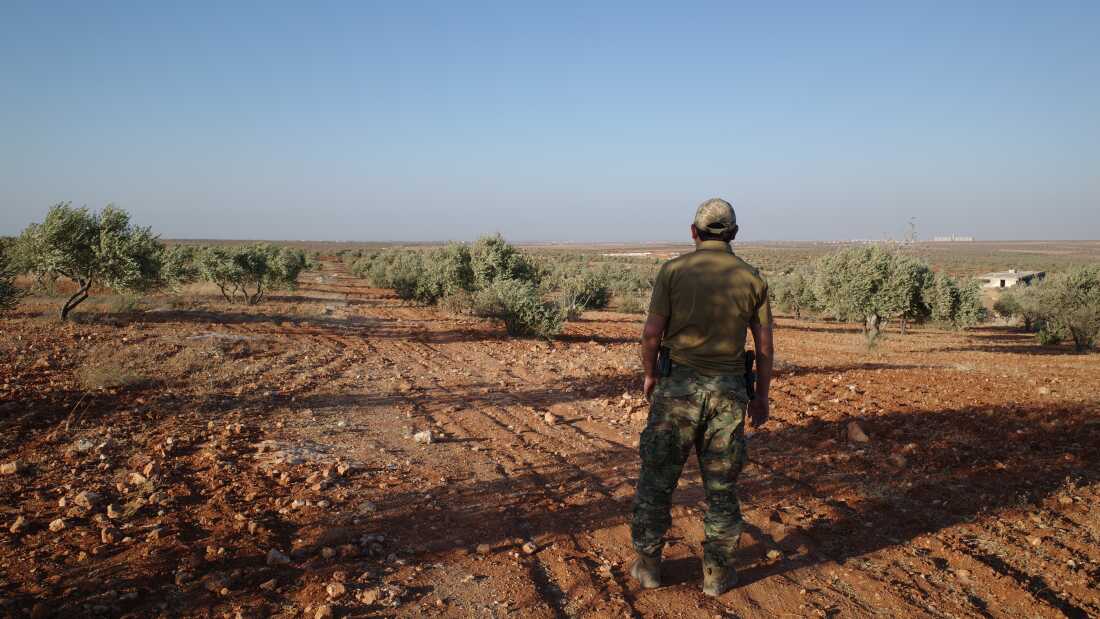 A senior Uyghur militant stands among an olive grove in northern Syria, where Uyghur commanders say their fighters began an ultimately successful assault on Syrian regime forces in November 2024.