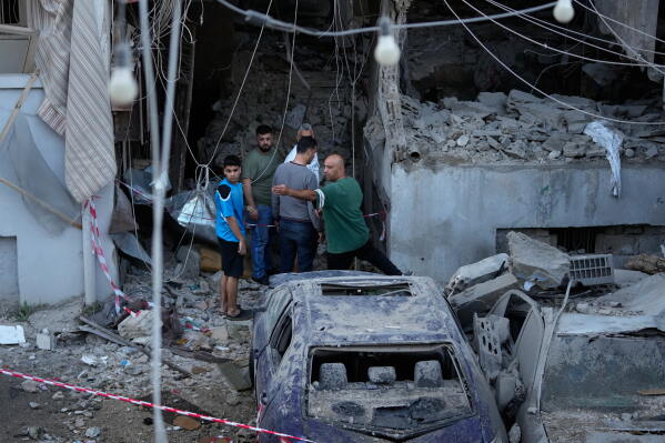 People gather outside a destroyed apartment that was hit in an Israeli airstrike in the southern port city of Sidon, Lebanon, Thursday, May 28, 2026. (AP Photo/Mohammed Zaatari)