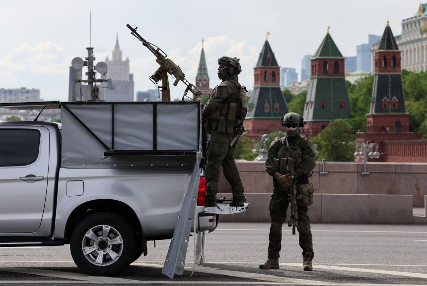 Russian security personnel stand guard next to a pickup truck equipped with a machine gun near the Kremlin in central Moscow on May 15.
