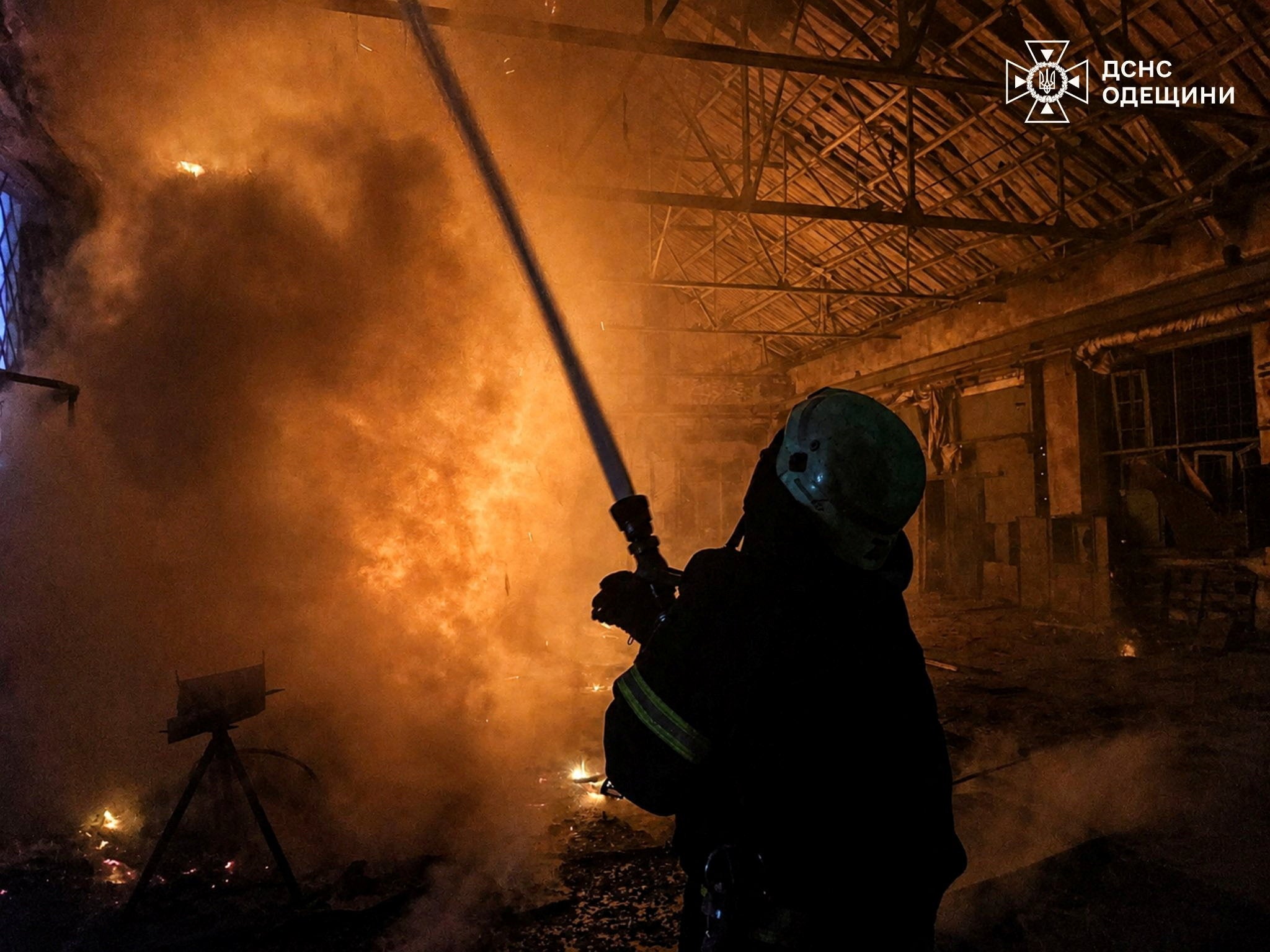 A firefighter tries to douse fire at compound of a port which was hit during overnight Russian drone strikes in the town of Izmail in Odesa