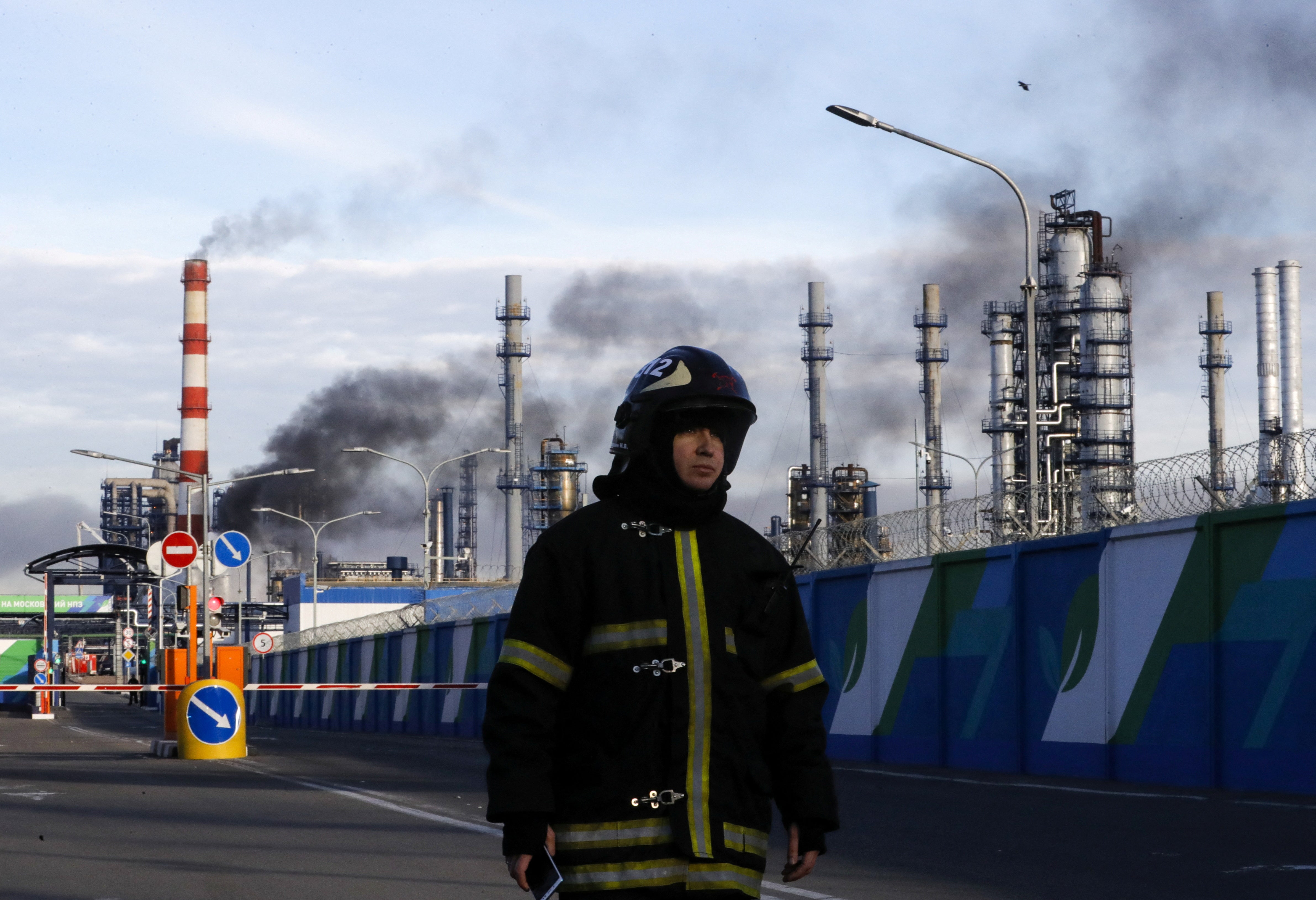 A firefighter is seen on a site, as smoke billows from a fire at oil refinery owned by Russian oil producer Gazprom Neft in Moscow