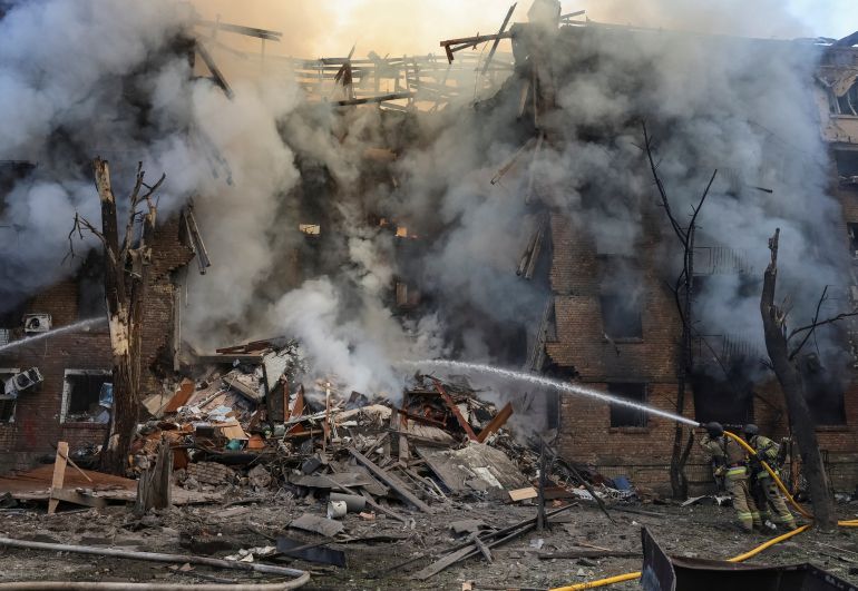 Firefighters work at the site of an apartment building destroyed by a Russian missile and drone strike