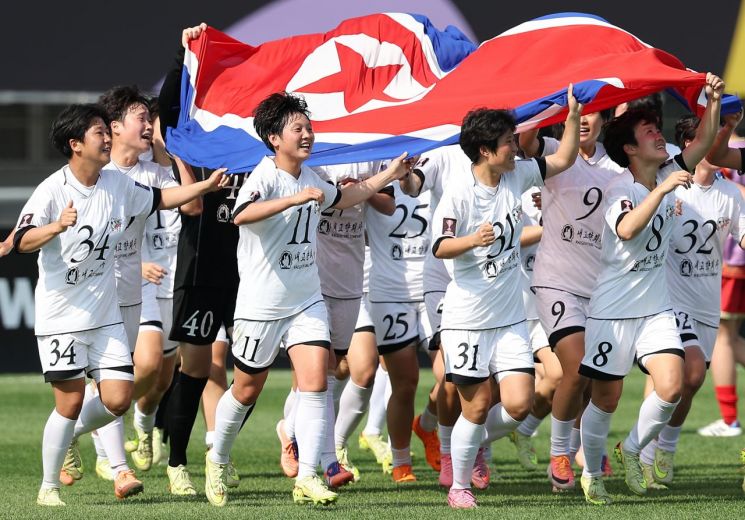 The winning Naegohyang players are running after unfolding the Korean Unification Flag. Photo by Yonhap News.