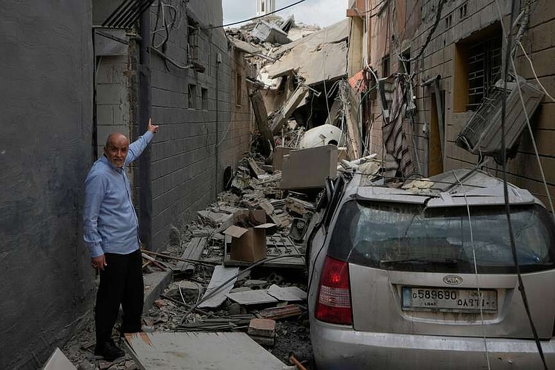 A man points into a destroyed building that was hit in an Israeli airstrike in Burj al-Shemali village near the southern port city of Tyre, Lebanon, Tuesday, May 26, 2026. (AP Photo/Mohammed Zaatari)