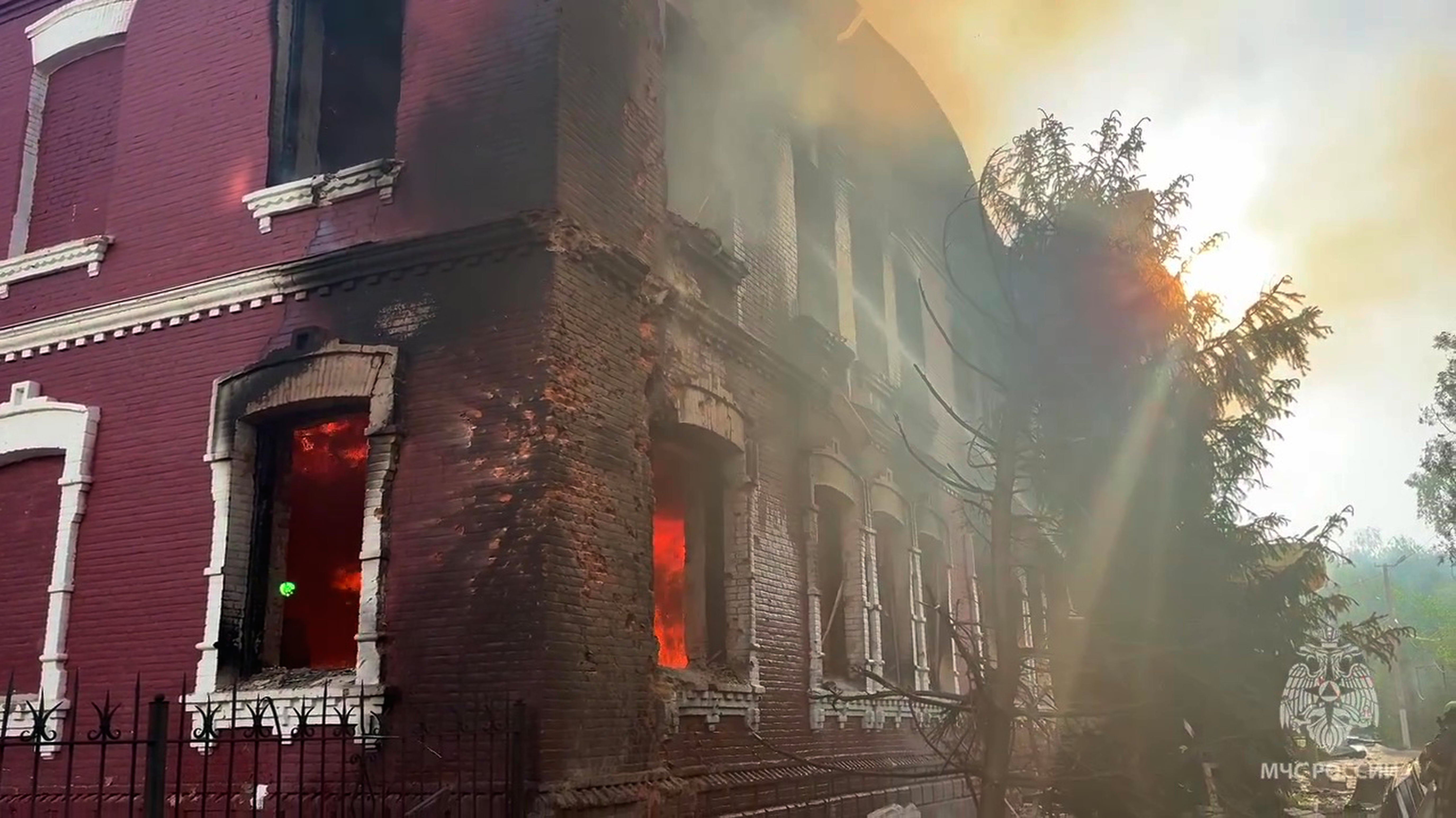 Flames and smoke rise from the side of a college building damaged by Ukrainian drones in Starobilsk, Ukraine