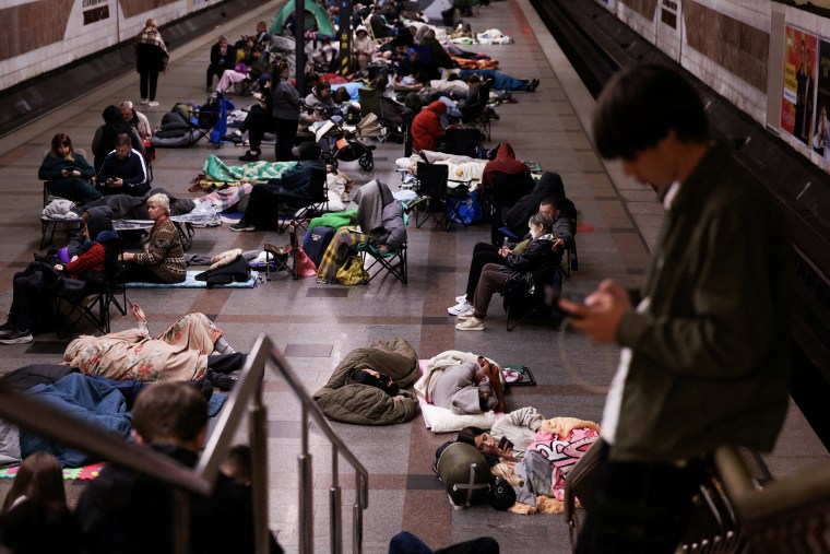 People take shelter in a metro station during an air raid.