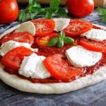 Raw Caprese pizza with tomato, mozzarella and basil leaves. arina7/iStock/Getty Images