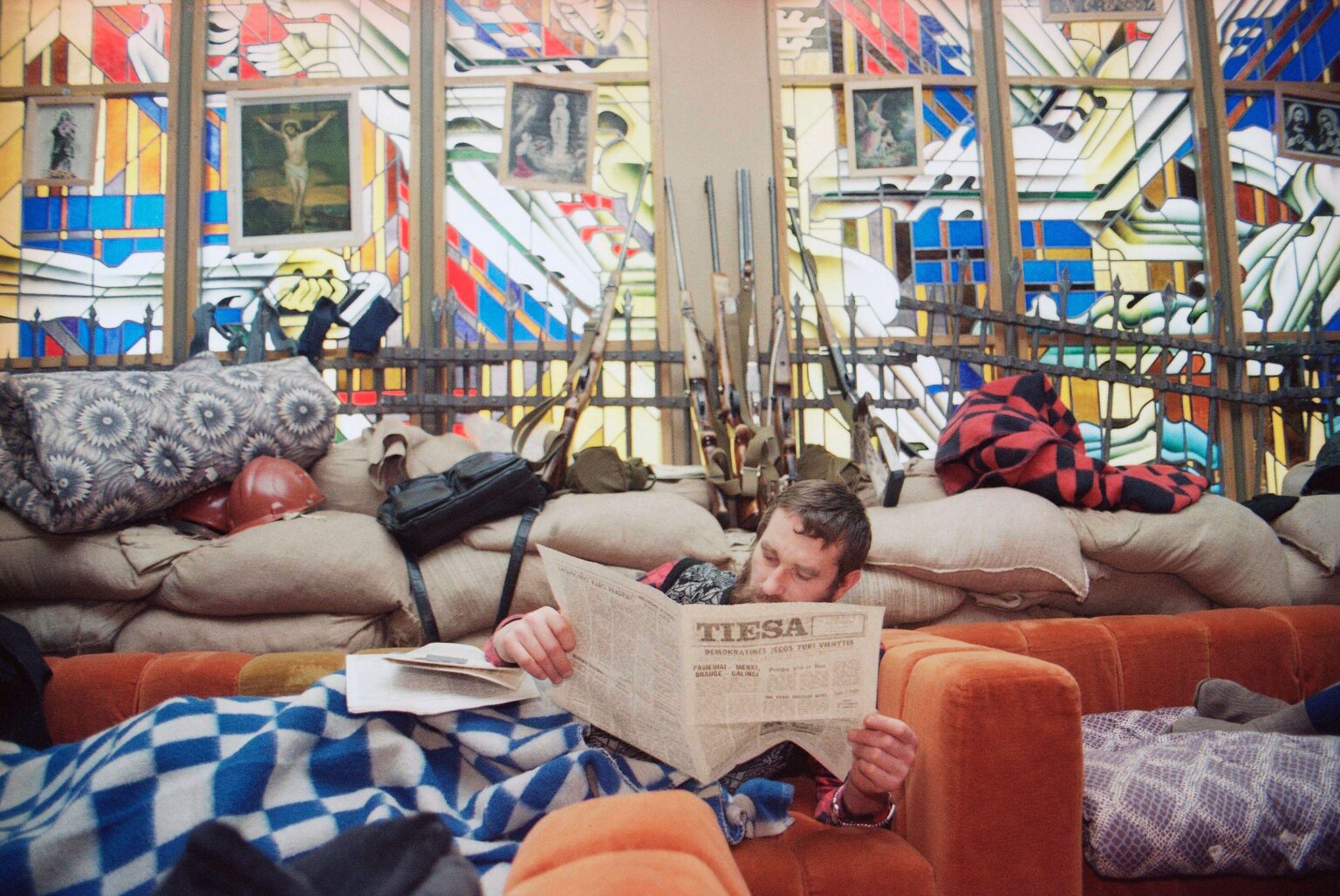 A volunteer guard resting behind makeshift barricades inside the Seimas (Parliament) in Vilnius. Following a Soviet military assault just weeks earlier, thousands of volunteers fortified the parliament building in a tense standoff to protect the nation's restored independence. (1991)