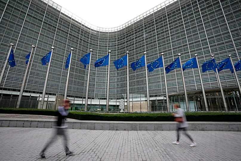 European Union flags flap in the wind as pedestrians walk by EU headquarters in Brussels, 20 September, 2023