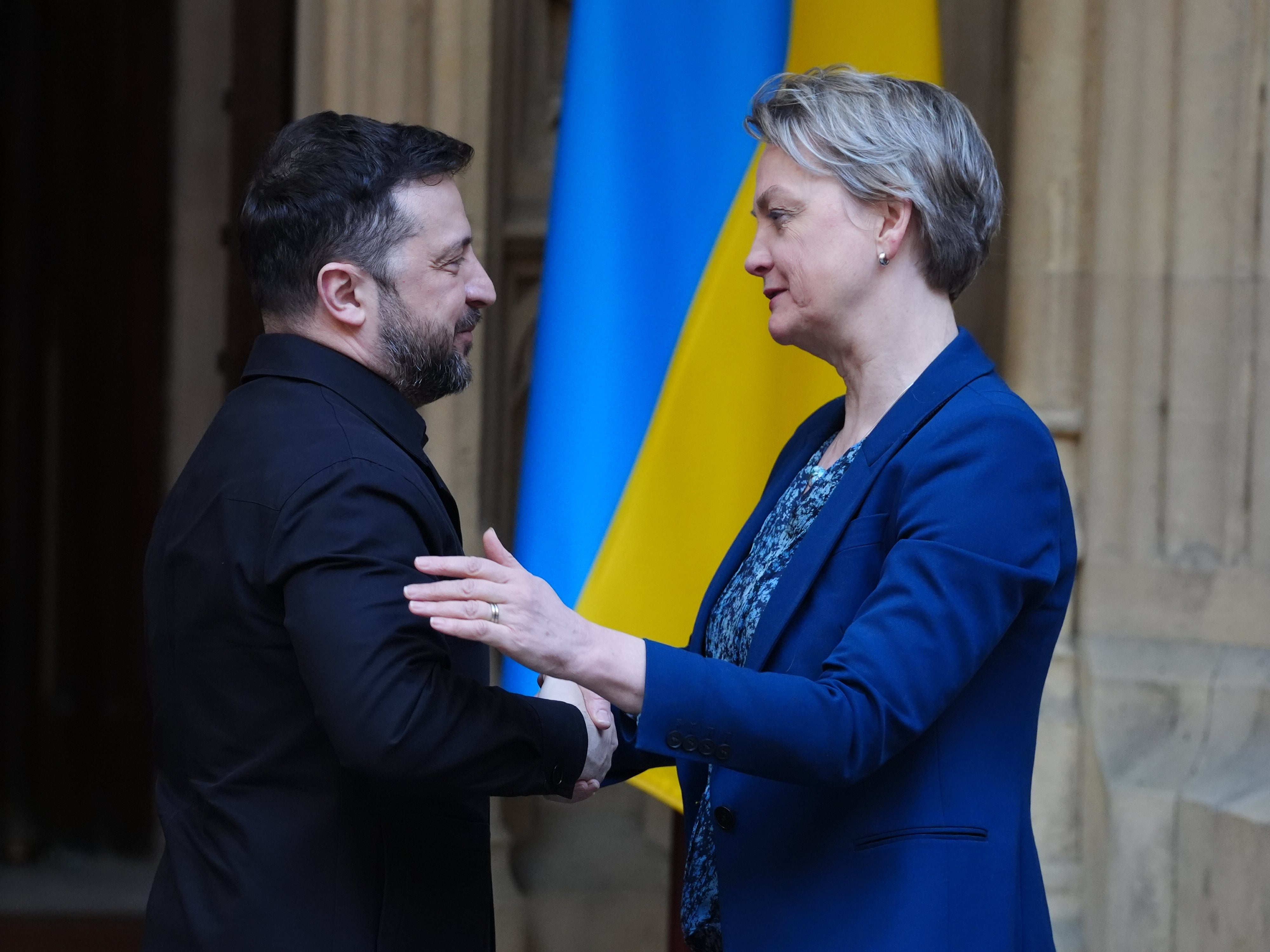 Ukrainian President Volodymyr Zelensky shakes hands with Foreign Secretary Yvette Cooper during a visit to the Houses of Parliament in March