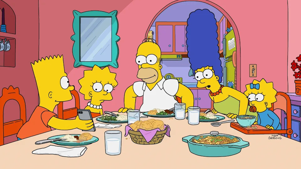 The Simpson family sits at the dining table, Bart on his phone, while food is served