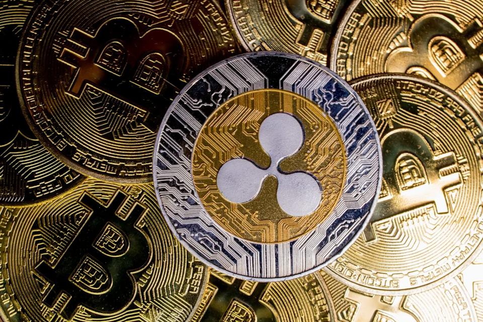 Ripple XRP coin on bitcoins background, cryptocurrency investing concept.