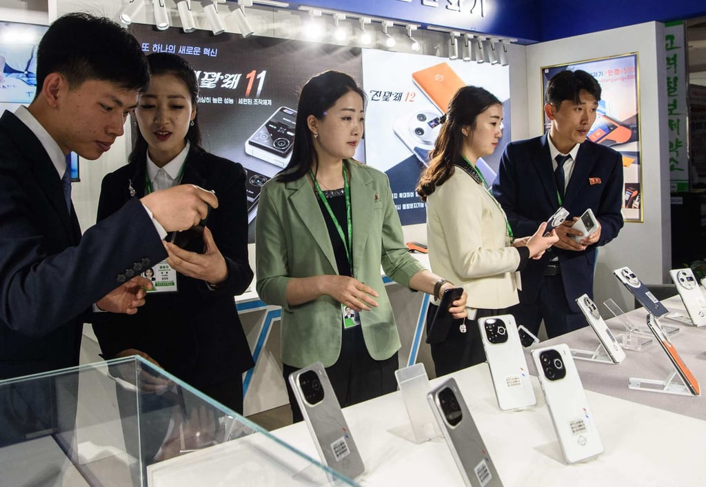 Visitors browse Jindallae mobile phones during the Pyongyang Spring International Trade Fair opening on Monday. Photo: AFP