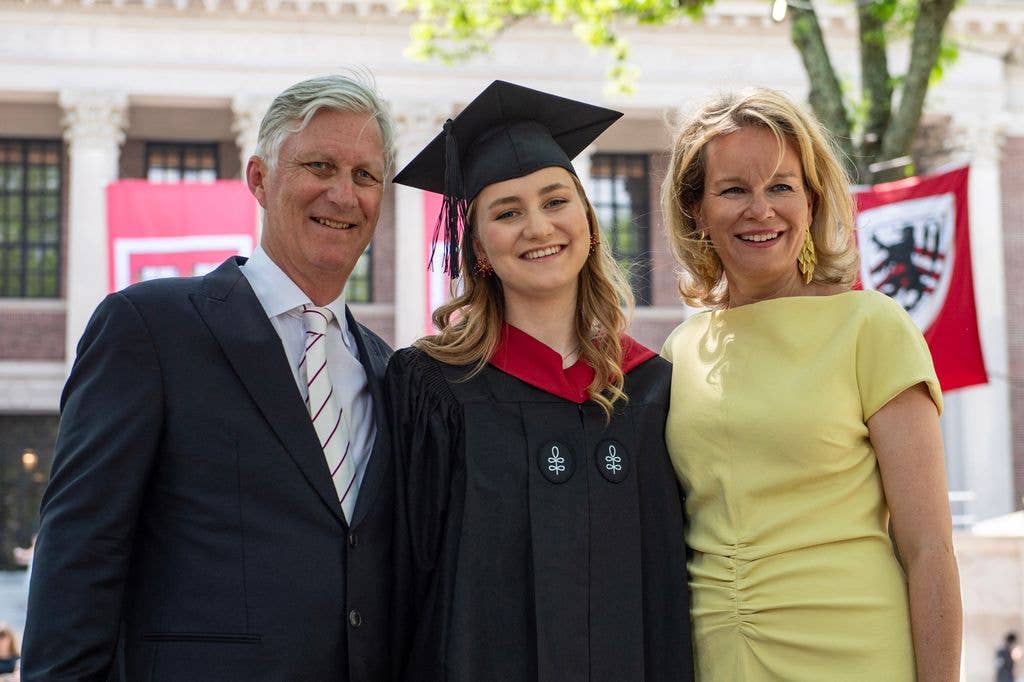 Princess Elisabeth of Belgium posing in her cap and gown next to her parents King Philippe and Queen Mathilde at Harvard Yard 