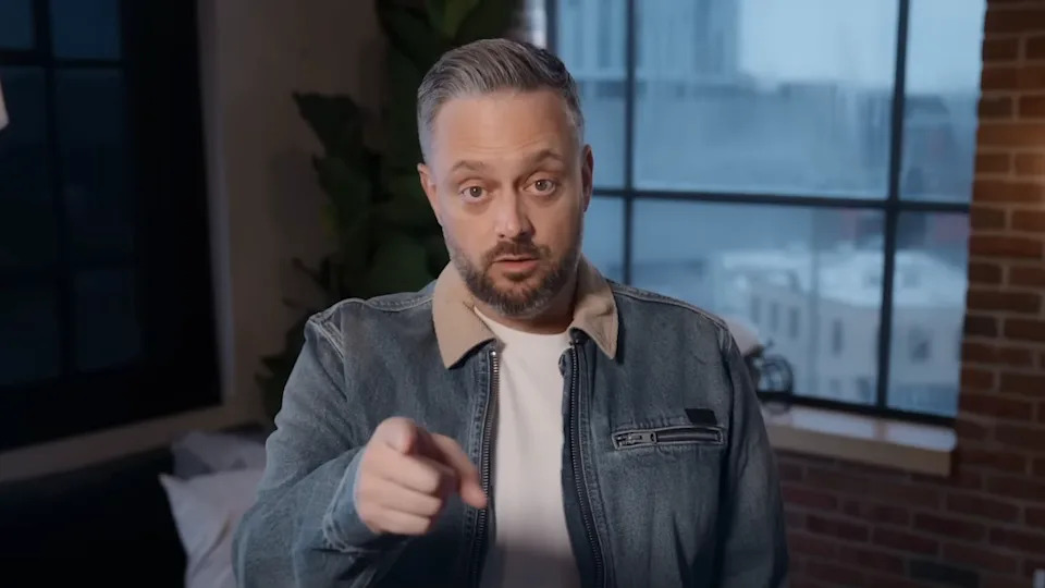 Nate Bargatze pointing to camera straight ahead while setting up the trailer for The Breadwinner .