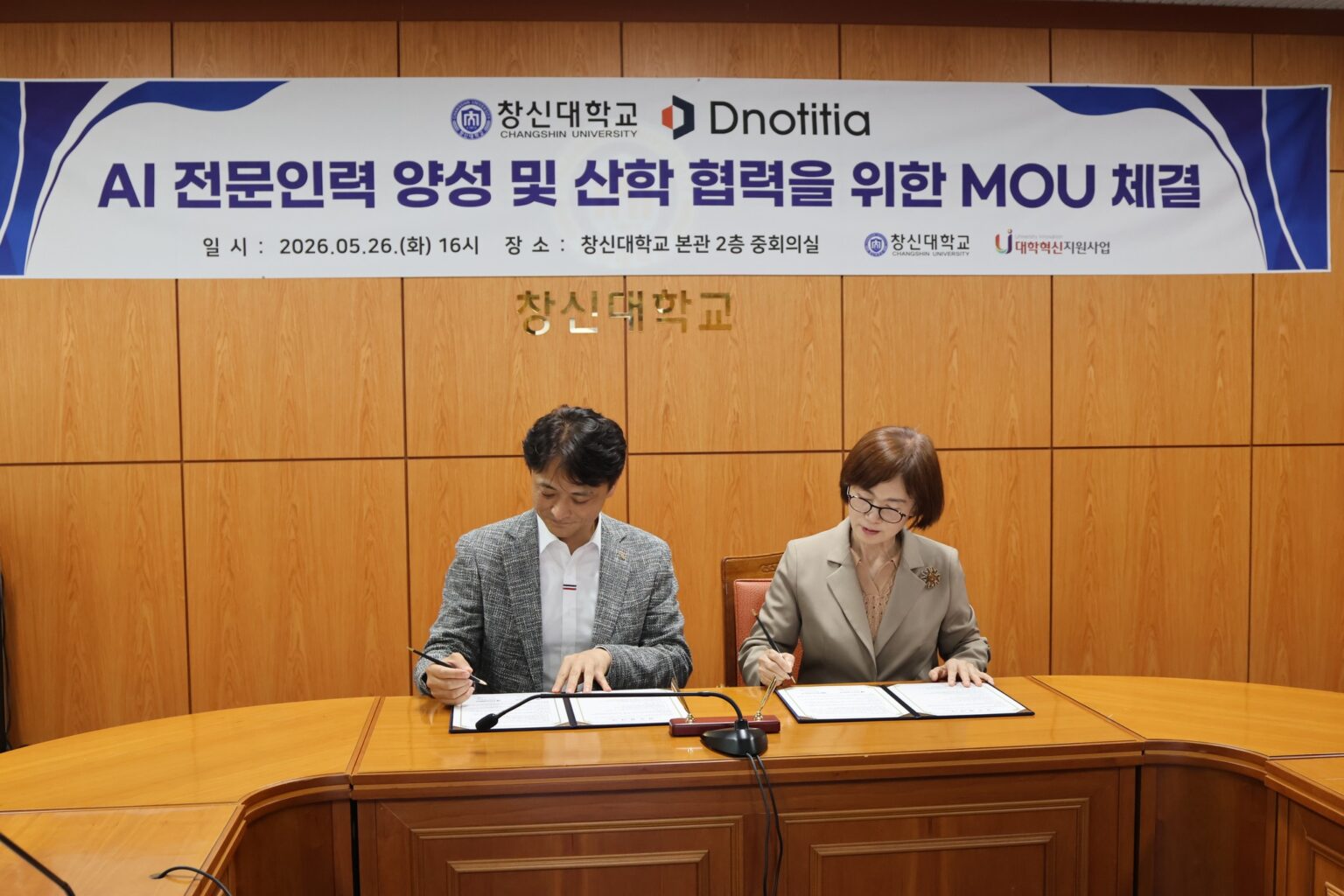 AI Firm, University Team Up to Train Future Defense AI Specialists in S.Korea Dnotitia CEO Jeong Mu-gyeong (left) and Changshin University President Choi Kyung-hee sign a defense AI talent and industry-academia partnership agreement in Changwon on May 26. Photo: Dnotitia/Facebook
