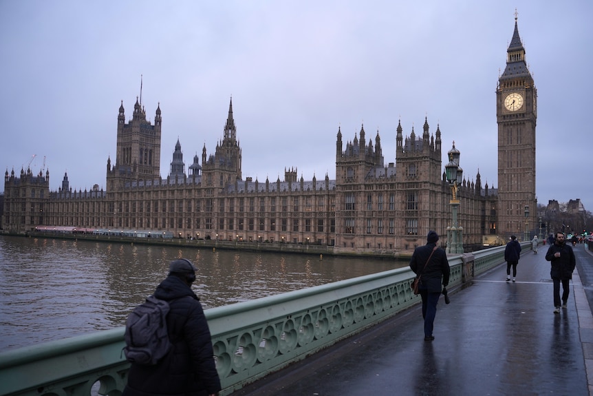 A view of the UK Houses of Parliament, including Big Ben, seen on a grey day from Westminster Bridge.