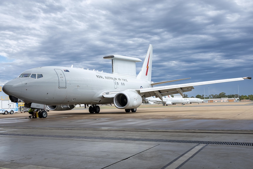 A large RAAF aircraft with a dorsal fin at an airbase. 