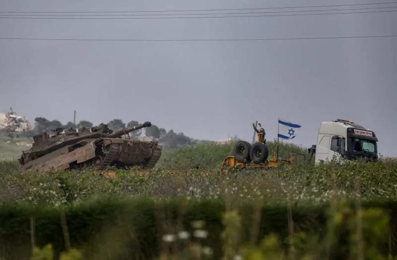 An Israeli soldier gestures to a tank to move forward as the tank goes onto a truck to move away from the site, on the Israeli side of the border with Lebanon, May 3, 2026. (credit: REUTERS/SHIR TOREM)
